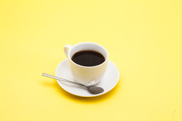 A cup of coffee on a yellow background