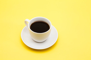 A cup of coffee on a yellow background