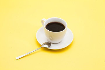 A cup of coffee on a yellow background