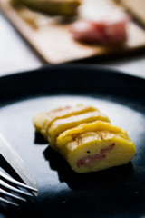 Roll made with smashed potatoes cheese and mortadella, on a wooden cutboard