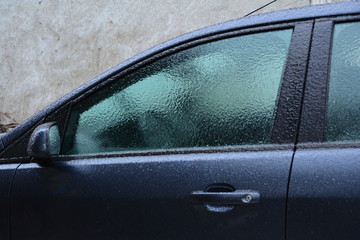 Obraz premium Frozen rain. Extreme weather. Danger for driving. Car locked.