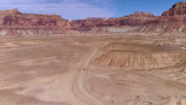 Aerial view of truck driving on dirt road in the Utah desert in the San Rafael Swell.