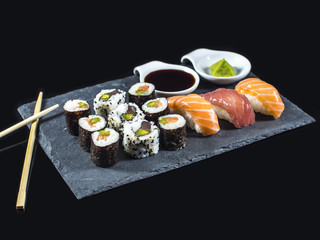 Sushi Set on Slate with Tuna and Salmon Sushis, Sushi Rolls and Wasabi on Black Background