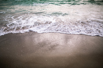 sea wave with foam on a sandy beach