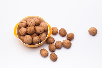 Yellow bowl full of walnuts isolated