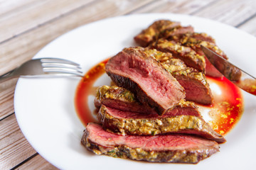 Pieces of fresh beef steak on a ceramic plate side view
