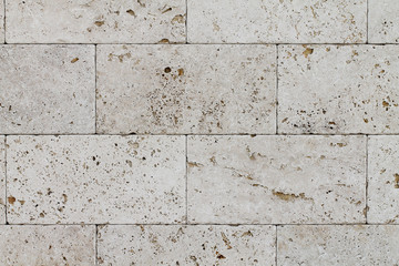 Natural Italian stone. Smooth travertine surface. A sample of wall cladding with natural stone.	