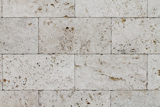Natural Italian stone. Smooth travertine surface. A sample of wall cladding with natural stone.	