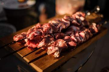 Set of skewers with stringed pieces of fresh meat arranged on the fooden desk