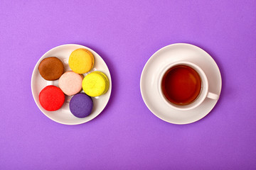 Colorful sweet macaroons and a cup of tea. Delicious breakfast. Top view.	