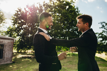 Groom talking with his best man at wedding party