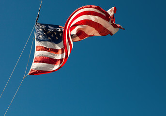 American flag blowing in the wind on the blue sky - 200454575