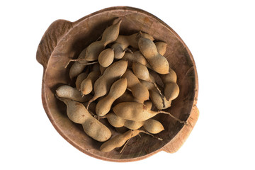 whole tamarind fruits in  round wooden bowl on white background