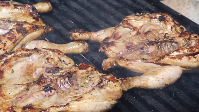 Grilled chicken thighs on the flaming grill.