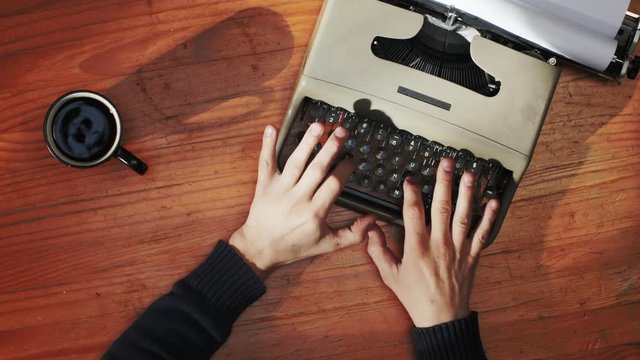 Book writing by the window with a vintage typewriter. 4K video colors and black and white