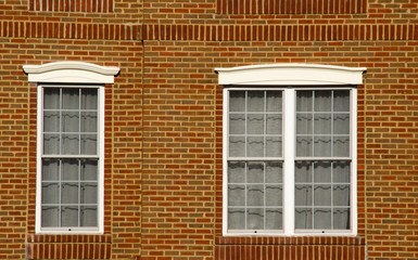 Obraz premium Dwa sąsiednie okna z tłem cegieł