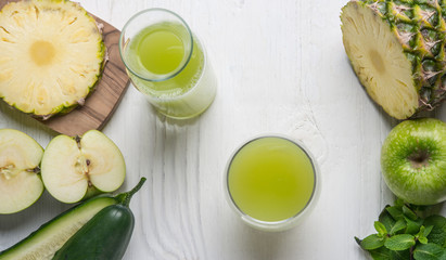 Top viev of glass juice made of cucumber, apple and pineapple