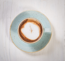 Top view cup of espresso coffee on white wooden table background