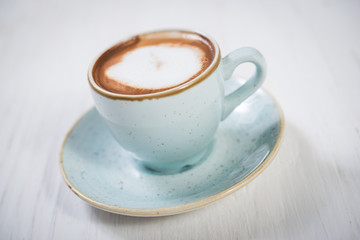 Blue cup of espresso coffee on white wooden background
