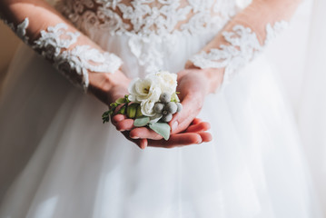 Slim beautiful young bride holding a boutonniere