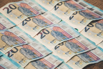 A close up of few twenty-euro bills are lined up on the ground.