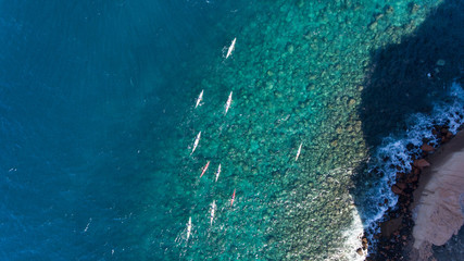 Aerial shots of people kayaking on a tropical island.