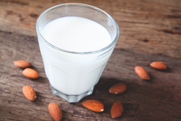 Close up glass of almond milk on rustic wooden table, Healthy food