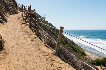A trail winding down a cliff toward the beach at Beacon's Beach in Encinitas, California.