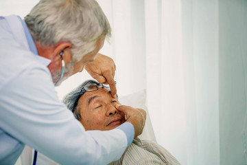 Obraz na płótnie Canvas Senior doctor checking his patient eyes