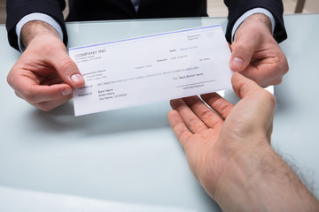 Businessman Giving Cheque To His Colleague