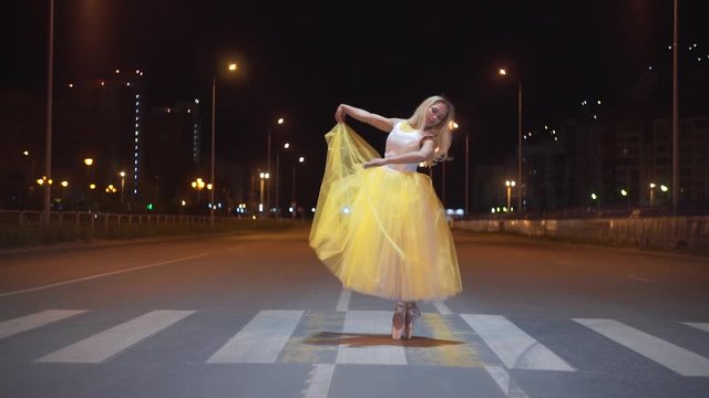 Beautiful ballerina dancing on a city street.