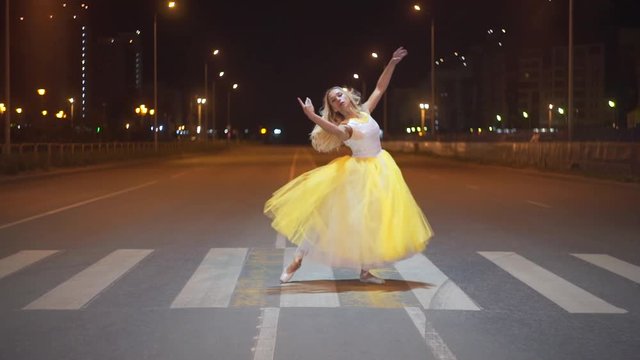 Beautiful ballerina dancing on a city street.