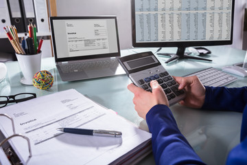 Businessperson Calculating Invoice