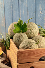 Close up cantaloupe melons in wooden box on wooden table