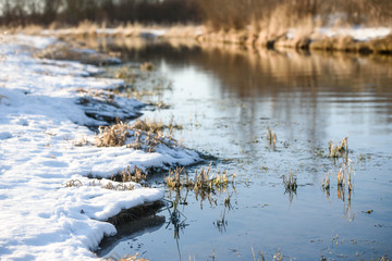 snow in the spring along the river