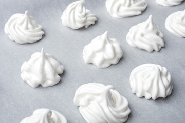 Whipped cream on baking paper. Meringue of the proteins and sugars. Step-by-step recipe for meringue cookies. Process of meringue preparation