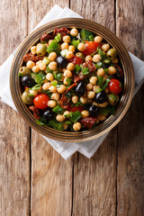 East balela salad with chickpeas, tomatoes, onions, olives and herbs closeup. Vertical top view