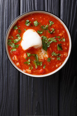 Sicilian fish tomato soup with vegetables close-up in a bowl. Vertical top view