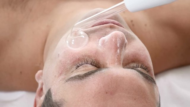 Darsonvalization. Man having darsonval therapy. Facial skin care in beauty saloon. electric darsonval massage procedure