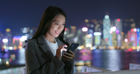 Business woman read on smart phone in city at night