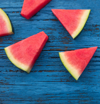 Watermelon fruit pieces  on a  blue rustic wood background, flat lay. Summer concept