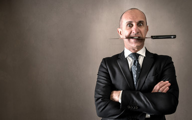 uomo d'affari con il coltello tra i denti