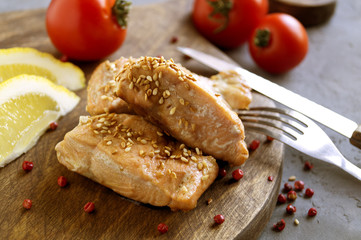 Cooked salmon fillet on a wooden Board.