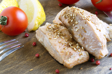 Cooked salmon fillet on a wooden Board.