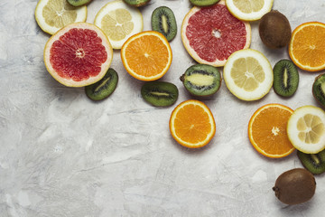Fototapeta na wymiar Fresh Fruits, Grapefruit, Lemon, Orange, Kiwi on a Light Stone background. Copy space and a top view