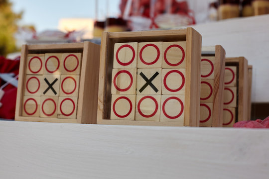 Tic-tac-toe game on white wooden background.