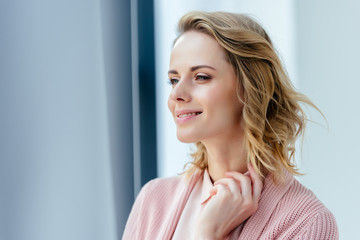 beautiful thoughtful woman in pink blouse and jacket looking away