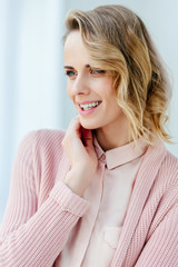 portrait of beautiful smiling woman in pink blouse and jacket looking away