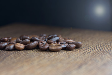 Texture of coffee beans on a wooden background close-up.