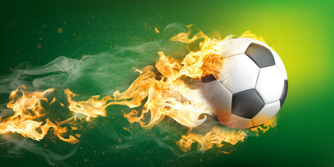 Fliegender und brennender klassischer Fußball aus Leder auf einem grünen Hintergrund